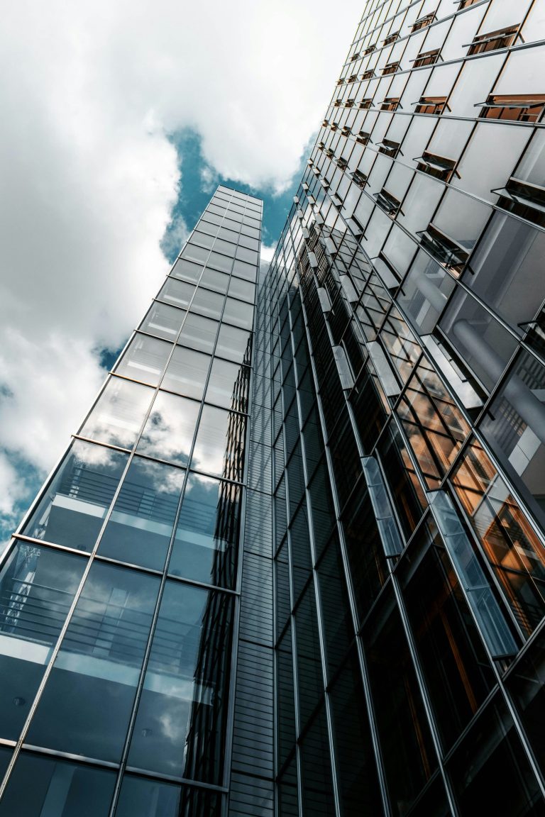 Glass facade of an office building reflecting the sky